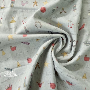 May include: Light blue fabric with a repeating Christmas-themed pattern. The design includes hand-drawn illustrations of stars, angels, gingerbread men, and holiday phrases like "hope" and "mistletoe". The fabric is suitable for various craft projects.
