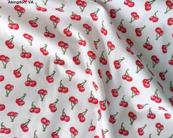 May include: White fabric with a repeating pattern of red cherries with green stems and leaves. The fabric is folded and has a small label that reads "My Little Fabric Shop Abingdon, VA".