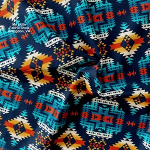 May include: A close-up of a fabric with a geometric pattern in shades of blue, orange, yellow, and white. The pattern is reminiscent of Native American designs.