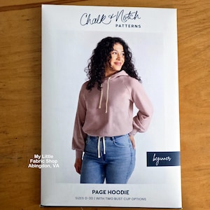 May include: A sewing pattern envelope for the Page Hoodie by Chalk and Notch Patterns. The cover features a mauve long-sleeve hooded sweatshirt with a drawstring, paired with blue jeans. Text includes sizes 0-30 and two bust cup options.