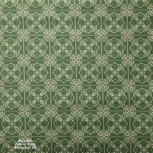 May include: A green fabric featuring a repeating white geometric pattern of interconnected floral motifs and thin grid lines. The design consists of symmetrical leaf-like shapes arranged in squares. Text in the bottom left reads My Little Fabric Shop Abingdon, VA.
