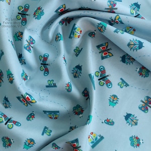 May include: Light blue fabric with a repeating pattern of colorful butterflies and ladybugs. The fabric has a subtle texture and a soft, drapey feel.  "My Little Fabric Shop Abingdon, VA"