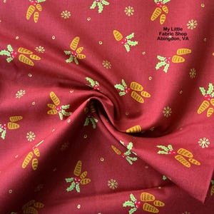 May include: A close-up of a red fabric with a repeating pattern of yellow corn, green holly leaves, red berries, and small yellow snowflakes. The text "My Little Fabric Shop Abingdon, VA" is visible in the upper right corner.