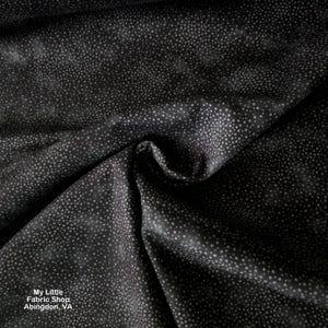 Puede incluir: Tela negra con un patrón de pequeños puntos grises claros. La tela está drapeada, mostrando pliegues y sombras. El texto "My Little Fabric Shop Abingdon, VA" es visible en la esquina inferior izquierda.