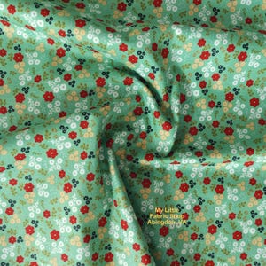 Peut inclure: Tissu vert avec un motif floral blanc, rouge et bleu. Le tissu est plié et le texte "My Little Fabric Shop Abingdon, VA" est visible dans le coin inférieur droit.