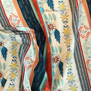 May include: A white fabric with a repeating pattern of colourful stripes and geometric shapes. The fabric has a blue, red, orange, and white colour scheme. The text "Crafts on Main" is visible in the image.