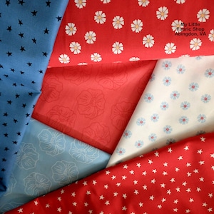 May include: A collection of cotton fabric swatches featuring various patterns including blue with black stars, red with white flowers, red with tonal floral outlines, light blue with white floral outlines, and white with small blue flowers. Text reads My Little Fabric Shop Abingdon, VA.