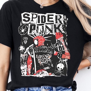 May include: Black t-shirt with the text "SPIDER PUNK" in white, featuring a red and black graphic design. The graphic includes a spider-like figure and other punk-inspired elements. The shirt is paired with blue jeans.