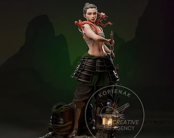 May include: A detailed figurine of a warrior woman in a gray top and black armor skirt, holding a weapon. A red dragon-like creature rests on her shoulder. The figure stands on a rocky base with a lantern and other accessories.