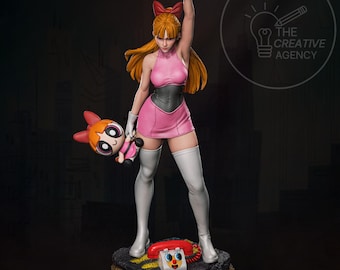 May include: A detailed figurine of Blossom from The Powerpuff Girls. She is wearing a pink dress, white gloves, and boots, with a red bow in her hair. She holds a plush toy of Bubbles and stands on a base with a telephone.