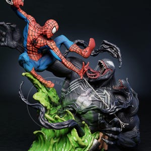 May include: A dynamic figurine depicting Spider-Man in a battle with Venom. Spider-Man is in a red and blue suit, while Venom is a black figure with a large mouth and sharp teeth. The base features green and black elements.