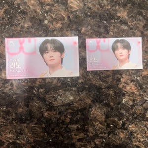 Puede incluir: Dos tarjetas rectangulares con un joven de pelo oscuro. Las tarjetas tienen un fondo rosa y blanco con texto coreano y las palabras "MC Special". La tarjeta m&aacute;s grande est&aacute; a la izquierda y la m&aacute;s peque&ntilde;a a la derecha.