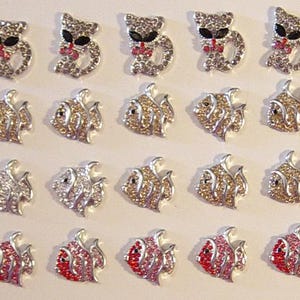 Può includere: File di abbellimenti a forma di gatto e pesce in strass. I disegni dei gatti hanno occhi neri e fiocchi rossi. I pesci sono in argento, oro, verde acqua e rosso. Ideali per l'artigianato.