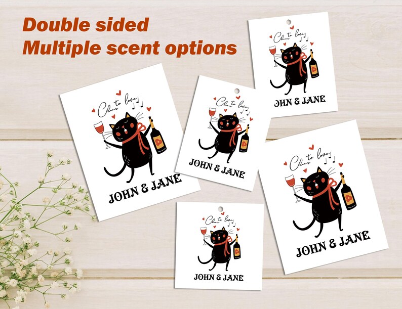 Op de afbeelding: Vier dubbelzijdige cadeaulabels met een zwarte kat die een glas wijn en een fles wijn vasthoudt. De tekst op de labels luidt "Cheers to love!" en "JOHN & JANE".