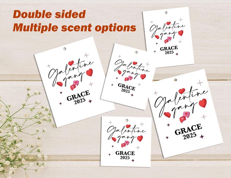 May include: White gift tags with the text "Galentine gang" in a script font, red hearts, and the year "2025". The tags have a small hole at the top for hanging. The words "Double sided" and "Multiple scent options" are also visible.