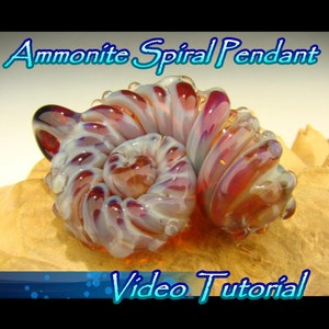 May include: A glass pendant in the shape of an ammonite spiral. The pendant is made of clear glass with red and white swirls. The pendant is sitting on a wooden surface. The text "Ammonite Spiral Pendant" is above the pendant and the text "Video Tutorial" is below the pendant.