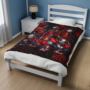 Può includere: Coperta nera con un gruppo di personaggi dei cartoni animati in abiti rossi e neri. I personaggi sono raffigurati in stile hip-hop, con catene d'oro e scarpe da ginnastica. La parola "HEEP" è visibile in bianco in basso a destra. La coperta è su un letto bianco.