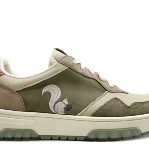 May include: Green and beige low-top sneakers with a white sole and a brown squirrel embroidered on the side.
