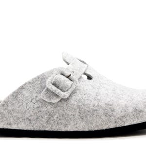 Peut inclure: Sabot en feutre gris avec une boucle de fermeture et un lit de pied en liège.