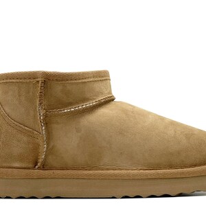 May include: Tan suede ankle boots with a shearling lining and a rubber outsole.