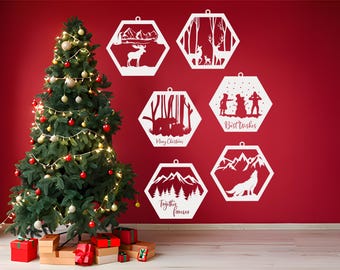 Pode incluir: Seis enfeites de Natal hexagonais brancos com várias cenas de inverno e texto. Os enfeites apresentam um alce, um veado, um boneco de neve, um urso, montanhas e um lobo. O texto nos enfeites diz "Feliz Natal", "Melhores votos" e "Juntos para sempre".
