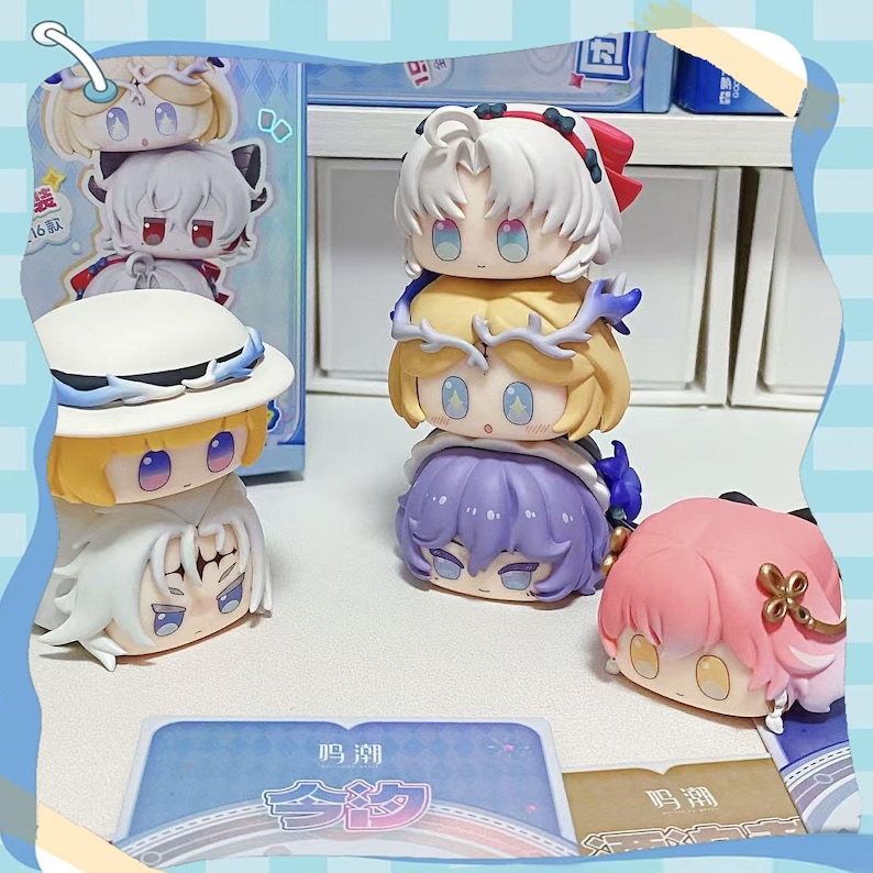 May include: A collection of chibi-style figurines with large eyes and various hair colors, including white, yellow, and pink. Some figurines are stacked, and others are displayed individually. The figurines have a cartoonish aesthetic.
