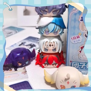 May include: A stack of five chibi-style figurines with colorful hair and outfits. The stack includes figures with purple, white, blue, and red hair. Two additional figurines are also visible, one purple and one cream-colored.