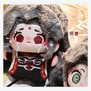May include: A plush doll with a sad expression, tears, and a gray fur hat. The doll has red eyes and a detailed outfit with red and black accents. The text "师尊..." is visible in the image.