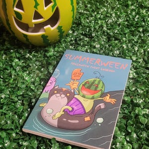 May include: A blue and green book with the title "Summerween Halloween Event Logbook". The cover features a cartoon watermelon character with a popsicle and a black cat in a pool float.