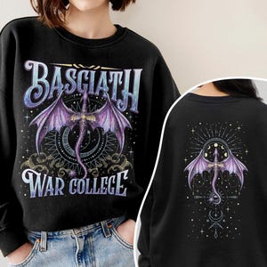May include: Black sweatshirt featuring a purple dragon design with the text "BASCIATH WAR COLLEGE". The dragon has outstretched wings and is centered on a celestial background. The back of the sweatshirt also features a dragon design.