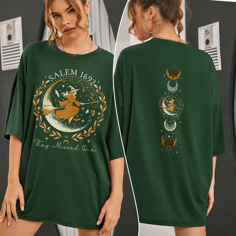 May include: Green t-shirt featuring a witch flying on a broomstick and a crescent moon with the text "Salem 1692 They Missed One". The back of the shirt has a vertical row of crescent moons with stars.