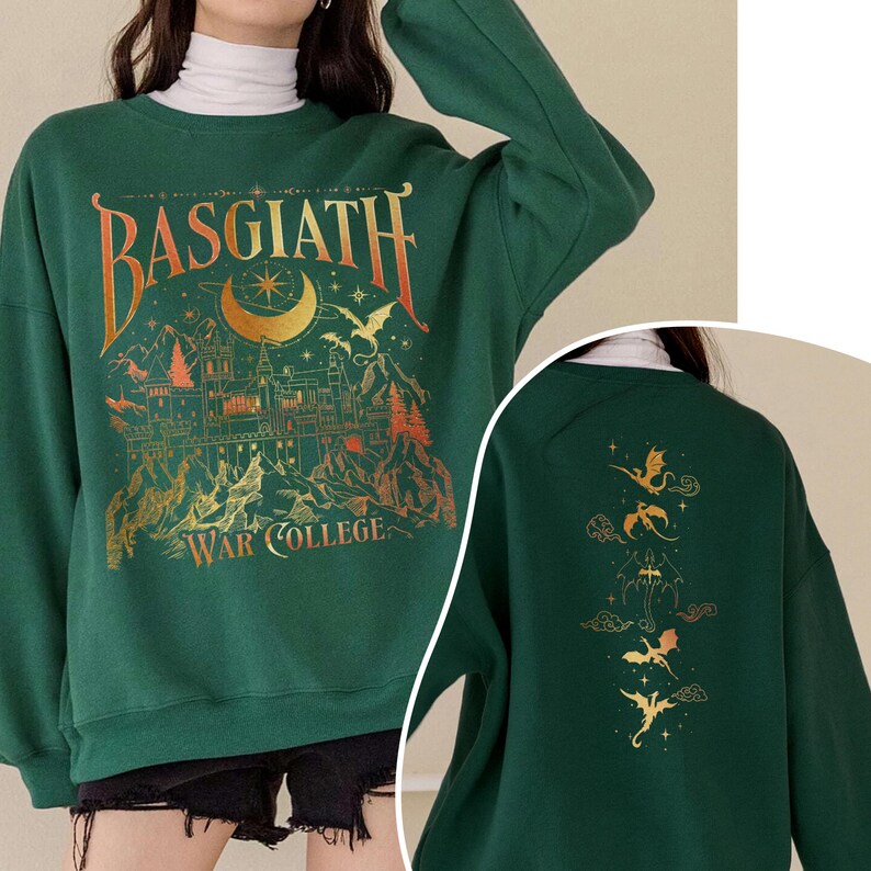 K&ouml;nnte beinhalten: Ein gr&uuml;ner Pullover mit einem goldenen Grafikdruck eines Schlosses und dem Text "Basgiath War College". Die R&uuml;ckseite des Pullovers hat einen goldenen Grafikdruck von f&uuml;nf Drachen.