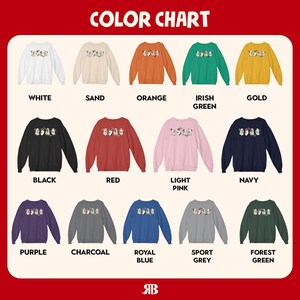 Puede incluir: Carta de colores que muestra 12 opciones de color diferentes para una sudadera. La sudadera presenta un estampado gr&aacute;fico de un grupo de personajes de dibujos animados. Los colores incluyen blanco, arena, naranja, verde irland&eacute;s, dorado, negro, rojo, rosa claro, azul marino, morado, carb&oacute;n, azul real, gris deportivo y verde bosque.