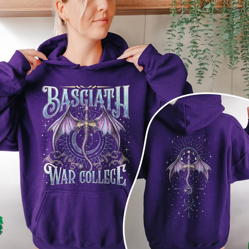 May include: Purple hoodie with a dragon graphic. The front features the text "BASCIATH WAR COLLEGE" above and below a detailed dragon illustration with wings. The back of the hoodie has a similar dragon design. A hooded sweatshirt.