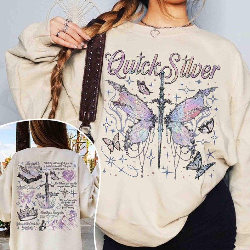 Peut inclure: Un sweat-shirt cr&egrave;me avec un motif de papillon avec une &eacute;p&eacute;e qui le traverse. Le texte "Quick Silver" est imprim&eacute; au-dessus du papillon. Le sweat-shirt a une coupe ample et un col rond.