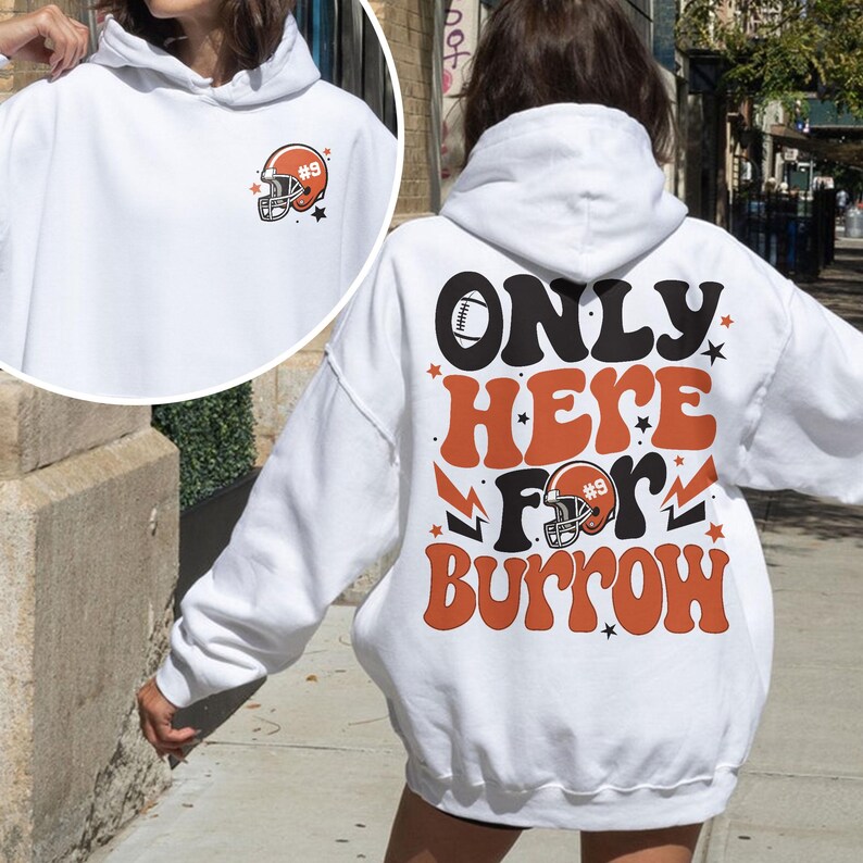 以下が含まれることがあります： オレンジと黒のグラフィックで、フットボールのヘルメットと「ONLY HERE FOR BURROW #9」の文字が描かれた白いフーディーです。