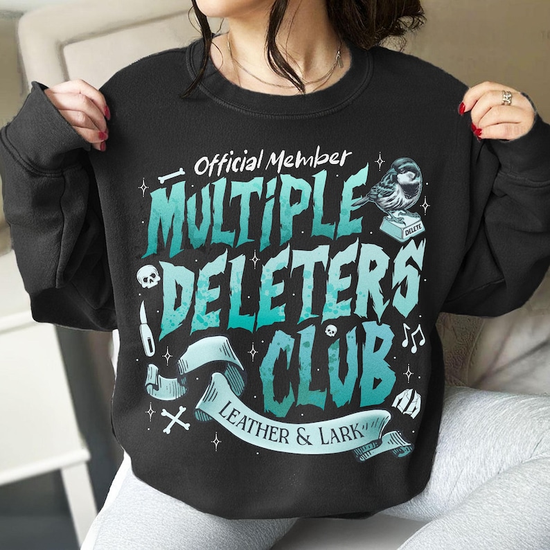May include: Black sweatshirt with a teal and white graphic design that says "Official Member Multiple Deleters Club Leather & Lark". The graphic also includes a small bird, a skull, and a cross.