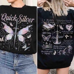 Peut inclure: Sweat-shirt noir avec un imprim&eacute; graphique d'un papillon, d'une &eacute;p&eacute;e et d'&eacute;toiles. Le texte "Quick Silver" est imprim&eacute; sur le devant du sweat-shirt. Le dos du sweat-shirt a un imprim&eacute; graphique d'un livre, d'une &eacute;p&eacute;e, d'une couronne et de papillons avec le texte "The devil is in the details", "Little Osha", "King Fisher", "Strike a bargain, pay the price", et "You should call her Majesty".
