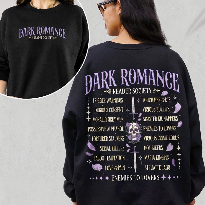 May include: Black sweatshirt with the text "DARK ROMANCE READER SOCIETY" in purple. The back features a skull with a sword and a list of dark romance tropes in purple, including "Enemies to Lovers" and "Trigger Warnings".