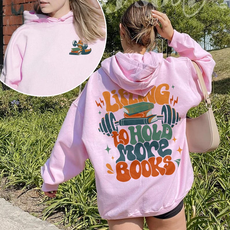 May include: Pink hoodie with a graphic of a barbell with books on it and the text "Lifting to hold more books".