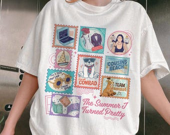 May include: White t-shirt featuring colorful postage stamp designs. Stamps include a laptop, wedding attire, a woman, a pizza, a bear, sunflowers, a giraffe, and books. Text on the shirt reads "The Summer I Turned Pretty", "Team Conrad", and "Cousins Beach".