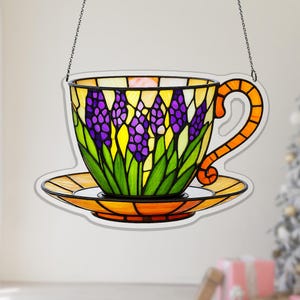 May include: A white ceramic mug with a black handle and the text "But First, Coffee" in a black, bold font. The mug is sitting on a wooden surface.