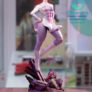 Puede incluir: Una figura de acci&oacute;n de superh&eacute;roe femenina blanca y morada de pie sobre una base de concreto rota. La figura tiene un traje blanco y morado con una capa blanca. La figura est&aacute; en una pose de acci&oacute;n din&aacute;mica. La figura es parte de un kit de modelo impreso en 3D.