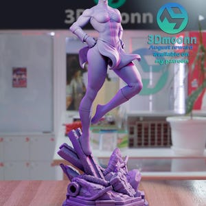 Puede incluir: Una figura impresa en 3D de color morado de una superhero&iacute;na femenina de pie sobre una base de concreto rota. La figura est&aacute; en pose con una pierna levantada y la otra doblada. La superhero&iacute;na lleva una falda corta y una capa. El texto "3Dmoonn August reward available on my patreon" es visible en el fondo.