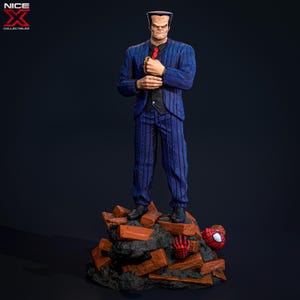 May include: A blue and black pinstripe suit figurine standing on a pile of broken bricks. The figurine has a bald head and a serious expression. A red spider-man figure is lying on the bricks.