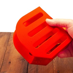 Puede incluir: Un contenedor de almacenamiento de pl&aacute;stico naranja brillante con cinco ranuras. El contenedor est&aacute; dise&ntilde;ado para guardar objetos peque&ntilde;os como bol&iacute;grafos, l&aacute;pices u otros art&iacute;culos de oficina.