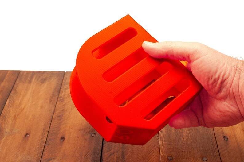 Puede incluir: Un contenedor de almacenamiento de pl&aacute;stico naranja brillante con cinco ranuras. El contenedor est&aacute; dise&ntilde;ado para guardar objetos peque&ntilde;os como bol&iacute;grafos, l&aacute;pices u otros art&iacute;culos de oficina.