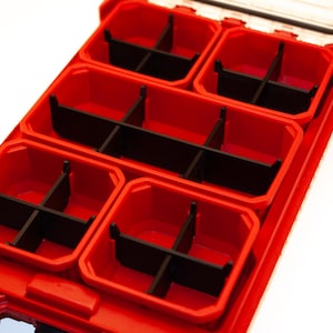 May include: A red plastic organizer with multiple compartments and black dividers. The compartments are arranged in a rectangular shape, ideal for storing small items. The organizer is designed for efficient organization and storage.