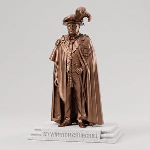 Op de afbeelding: Een bronskleurig standbeeld van Sir Winston Churchill met een hoed met veren, een lange cape en formele kleding met een zwaard aan de heup. Het figuur staat op een rechthoekige witte voet met de tekst Sir WINSTON CHURCHILL in de voorzijde.