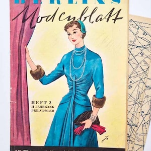 May include: A vintage fashion magazine cover, "BERLINS Modeblatt", showing a woman in a teal dress, pearl necklace, and fur cuffs. German text is visible, along with a pattern sheet.